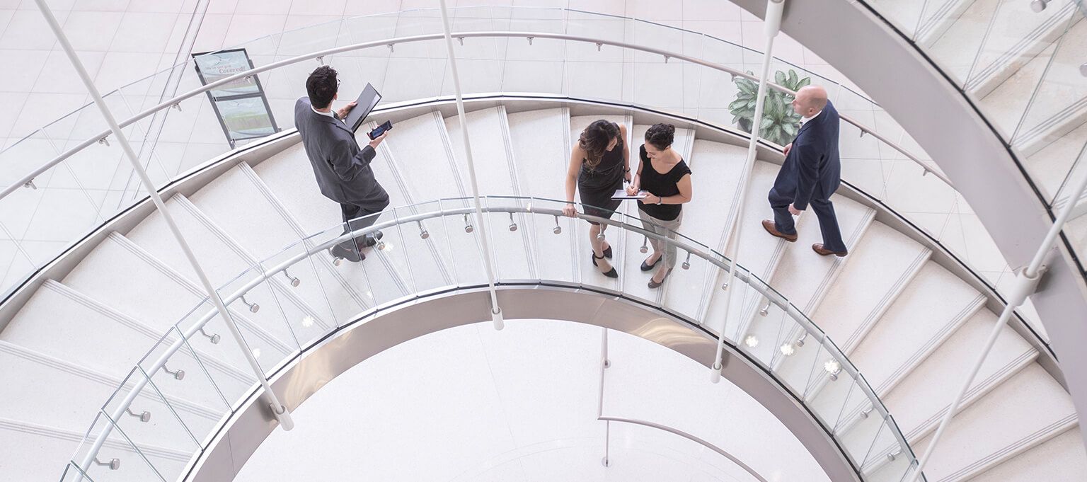 a group of people walking down a spiral staircase